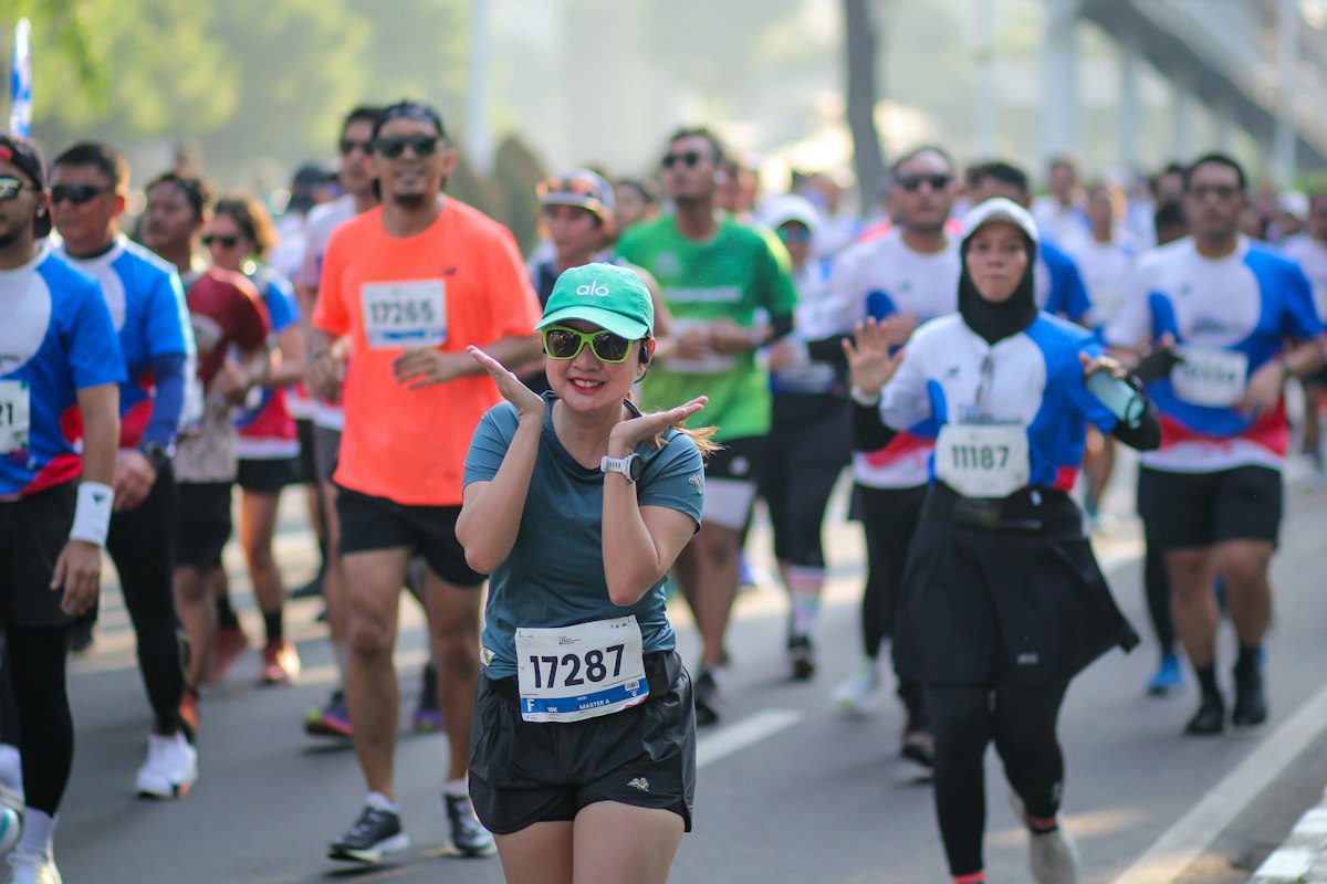 Smiling runners in a road race, bibs on
